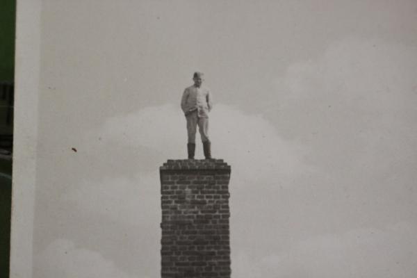 junger Soldat auf Denkmal mit Hakenkreuz